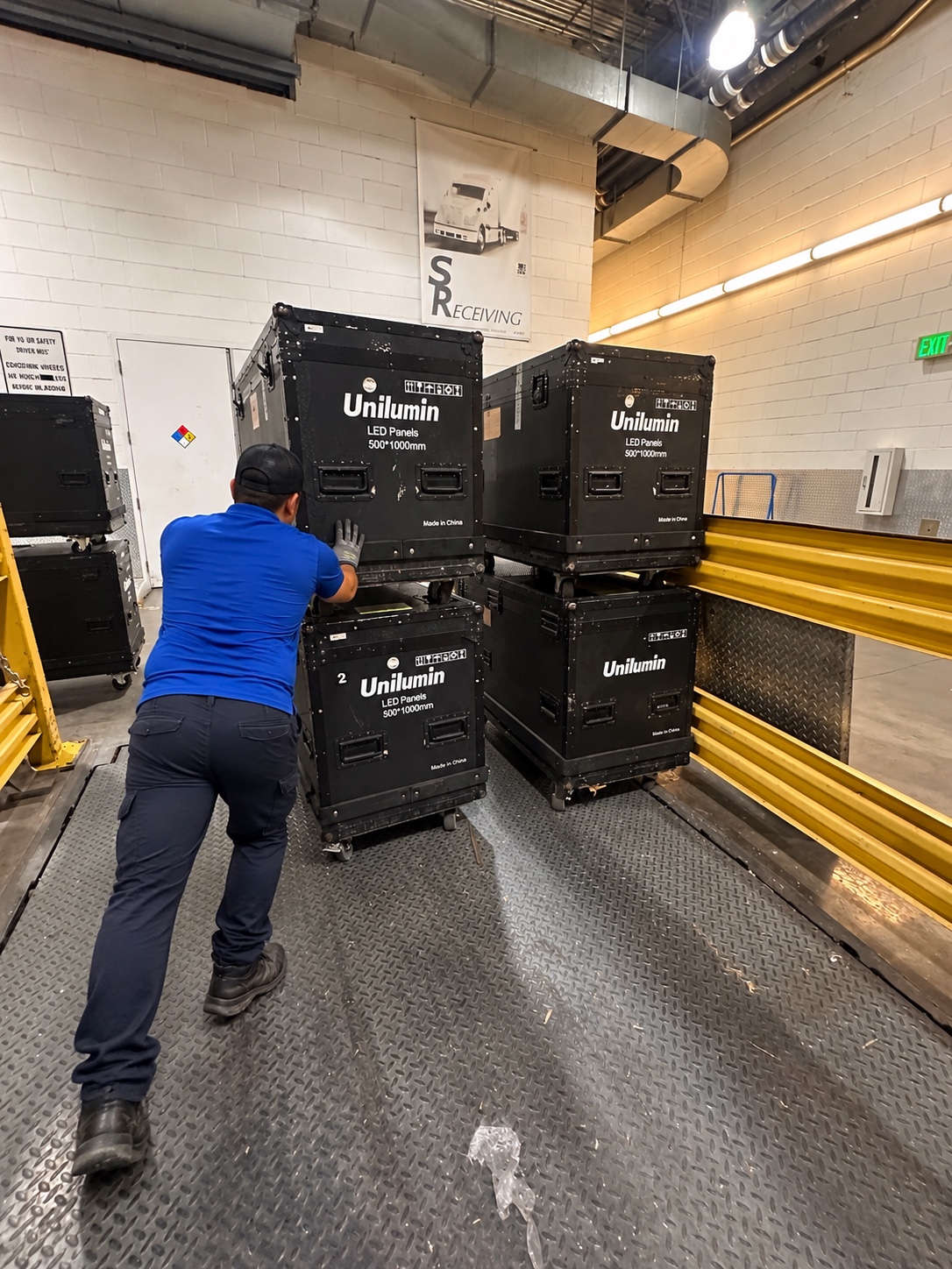 Worker handling equipment cases at a receiving dock