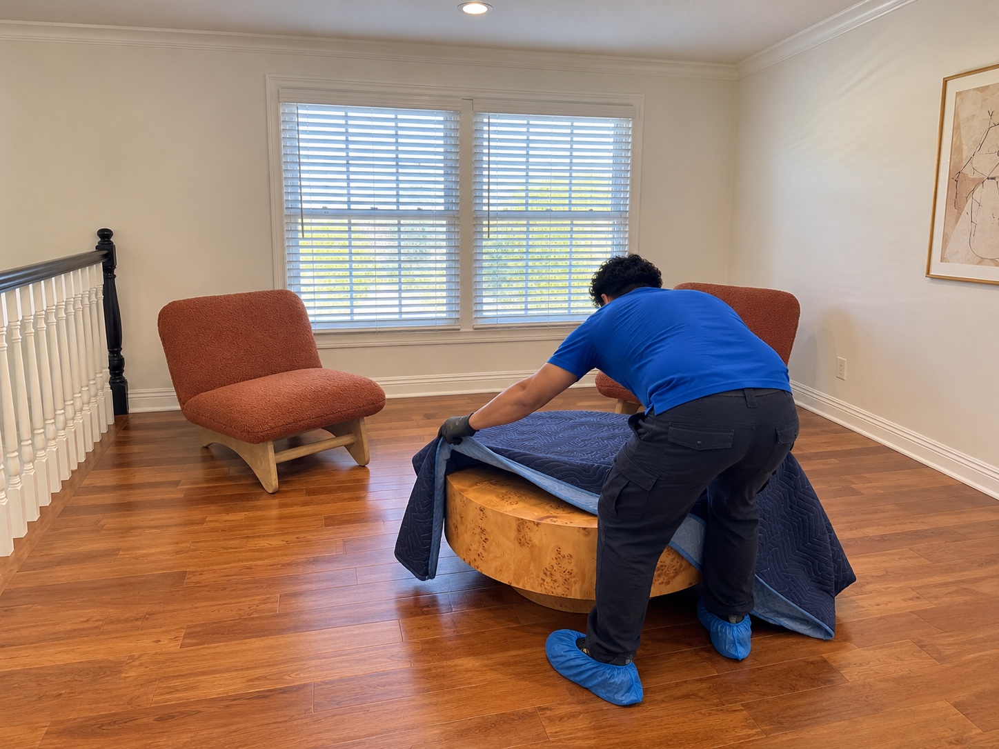 Worker covering a coffee table with a moving blanket